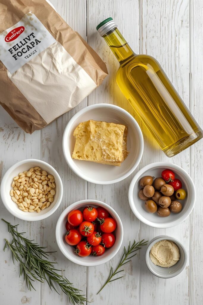 A vibrant flat lay of the main ingredients for focaccia: flour, water, yeast, salt, olive oil, and various festive toppings like cherry tomatoes, rosemary, and olives, arranged on a kitchen counter.
