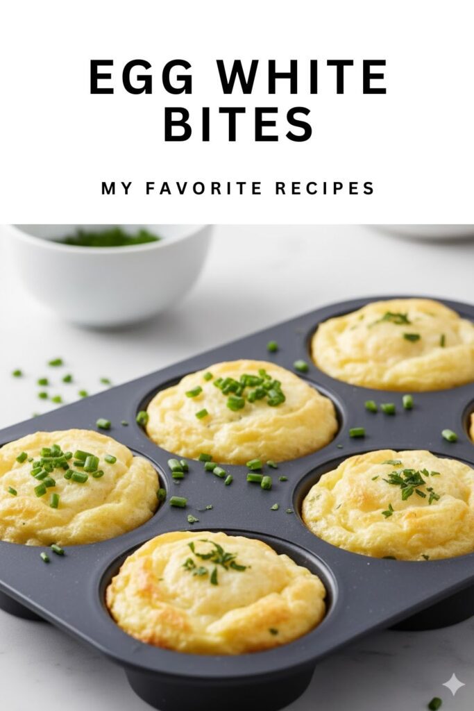 A close-up image of fluffy, golden-brown egg white bites in a muffin tin, garnished with fresh herbs, with the text overlay "Egg White Bites."