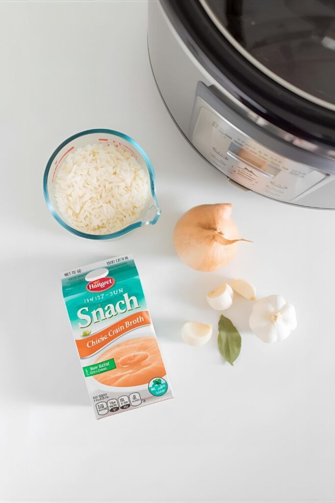 A flat-lay image of the ingredients for slow cooker rice, including rice, broth, and aromatics, arranged next to a Crock-Pot.