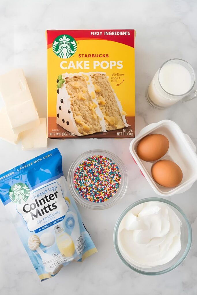 A neat flat lay collage of all the ingredients for Starbucks cake pops: a yellow cake mix box, a container of vanilla frosting, butter, eggs, milk, a bag of white candy melts, and colorful sprinkles, arranged on a clean kitchen surface. `