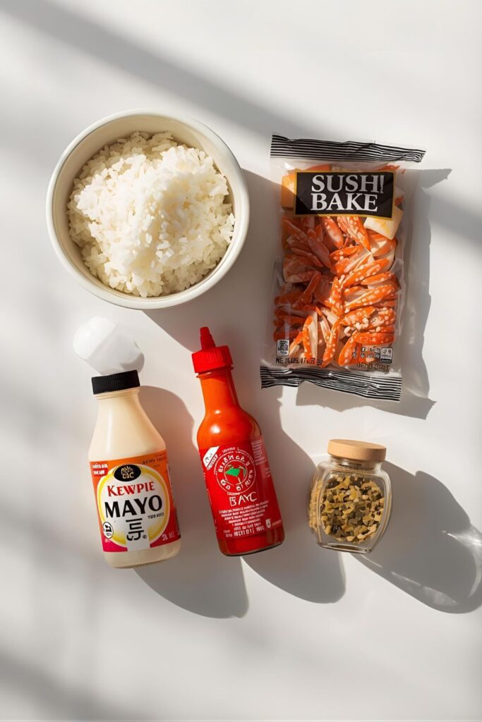 A flat lay of ingredients for a sushi bake: sushi rice, imitation crab, Japanese mayo, sriracha, rice vinegar, and furikake.