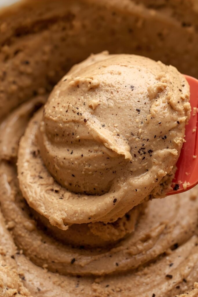 A slice of rich chocolate cake topped with a perfect swirl of coffee frosting, ready to be served