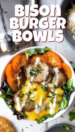 A vibrant, deconstructed bison burger bowl featuring a sliced bison patty, melted cheese, lettuce, tomatoes, and a creamy sauce drizzle. Text overlay reads: BISON BURGER BOWLS