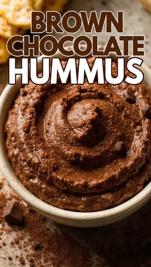 A close-up, vibrant overhead photo of creamy brown chocolate hummus in a small bowl, garnished with a cocoa dusting and chocolate chips, featuring the bold text overlay: BROWN CHOCOLATE HUMMUS.