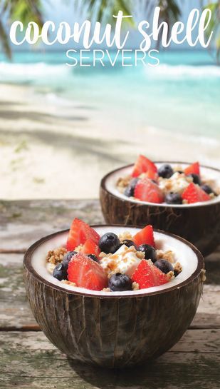 Two perfectly cut and polished coconut shell servers filled with vibrant tropical fruit and granola, set on a sandy surface. Text overlay reads: COCONUT SHELL SERVERS