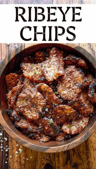 A pile of perfectly thin, dark, and crispy ribeye chips stacked in a rustic bowl, dusted with salt and pepper. Text overlay reads: RIBEYE CHIPS