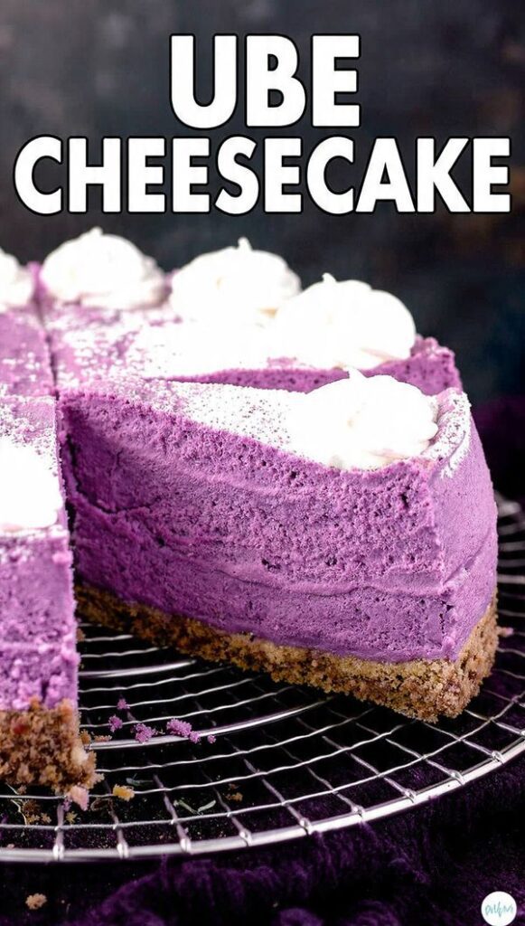 A slice of bright purple Ube Cheesecake on a white plate with a fork. The texture is creamy and smooth. The text overlay reads: "UBE CHEESECAKE".