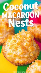 A close-up of a golden coconut macaroon nest with chocolate and candy eggs with text overlay "Coconut Macaroon Nests".