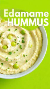 A bowl of vibrant green edamame hummus topped with olive oil and sesame seeds with text overlay "Edamame Hummus".