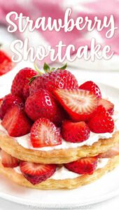 A tall, assembled strawberry shortcake with whipped cream and berries with text overlay "Strawberry Shortcake".