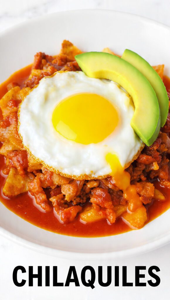 A close-up of a steaming skillet of chilaquiles with a runny egg.