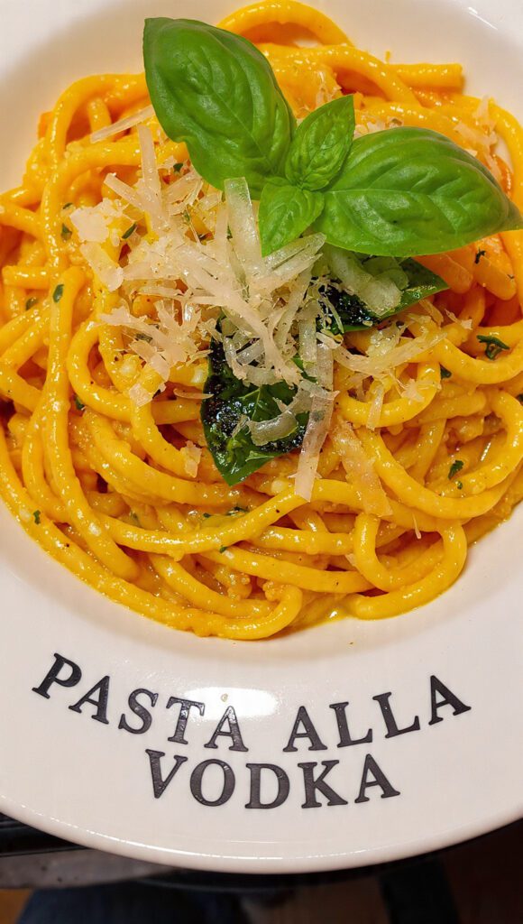 A delicious plate of authentic silky pasta alla vodka with basil.